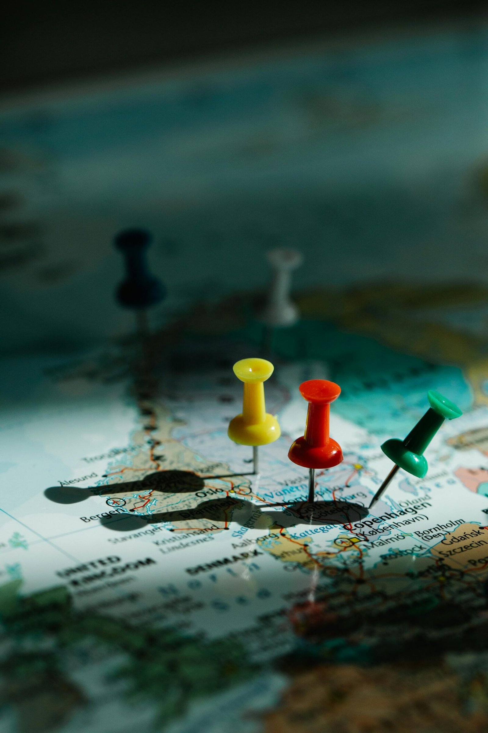 Close-up of colorful pins on a world map, highlighting travel planning and exploration.
